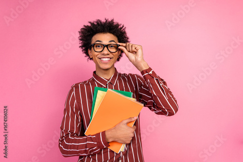 Canvastavla Stylish young man posing with glasses and colorful notebooks against a pink back
