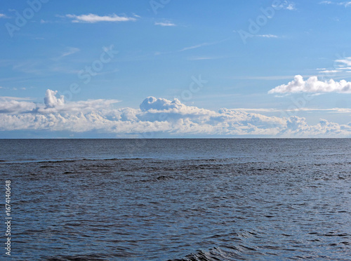 Calm sea and blue sky - A tranquil, minimalist landscape of the sea and sky, with a low line of distant white clouds
