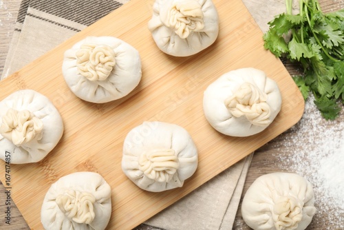 Wallpaper Mural Uncooked khinkalis (dumplings) and cilantro on wooden table, flat lay Torontodigital.ca