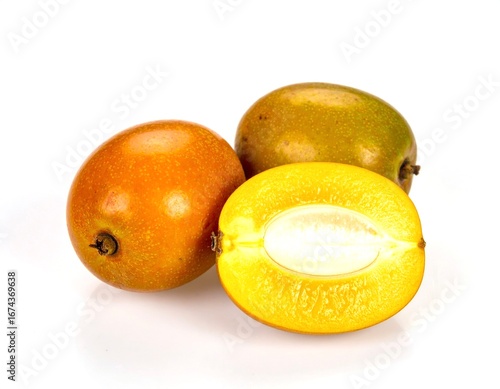 Fresh jocote fruits displayed with a halved section revealing the seed on a white surface