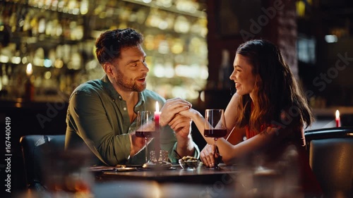 Loving boyfriend talking girlfriend holding hands in luxury night club closeup.