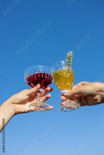 Cheers to a sunny day with colorful drinks under a clear blue sky, celebrating life and friendship