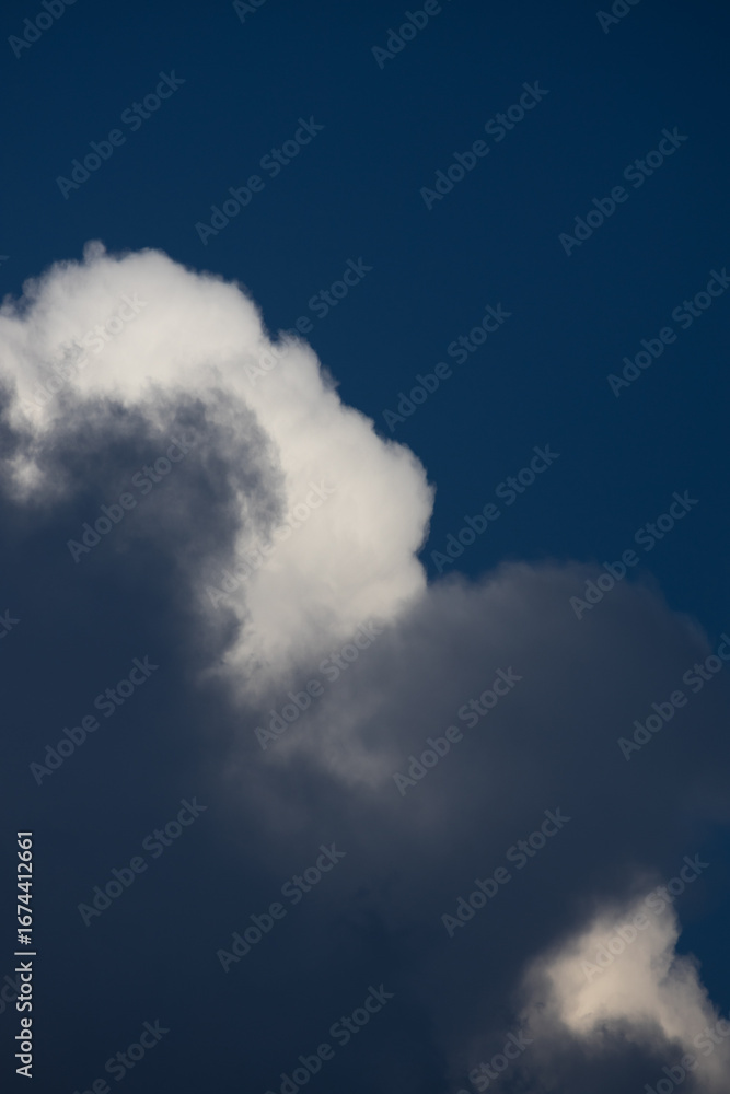 Obraz premium Dramatic cloud formations swirl against a deep blue sky at sunset creating a stunning backdrop for nature's beauty