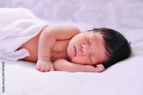 Wallpaper Mural A peaceful newborn baby sleeping soundly on a soft white blanket, embodying the innocence of early life. Torontodigital.ca