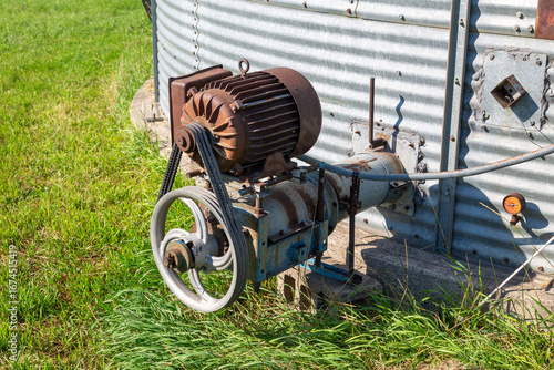 Obraz na płótnie Grain bin motor and auger pulley system on farm silo close up