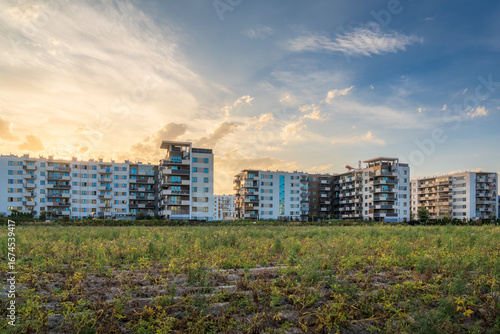 wyrastające nowe osiedle mieszkaniowe w Warszawie pomiędzy polami uprawnymi