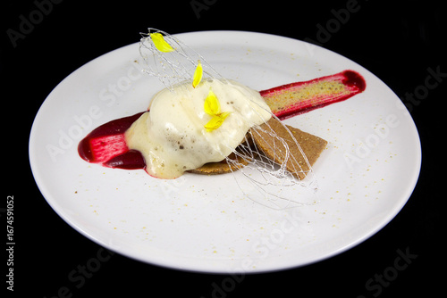 Exquisite dessert, with sweet, fruity sauce and caramel. Haute cuisine.
Sweet menu. On a white plate, with a black background.