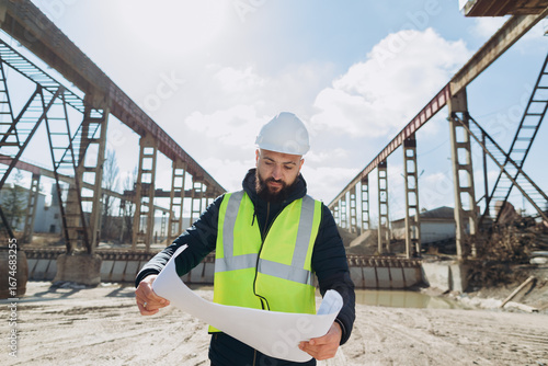 Vászonkép Engineer reading blueprint at concrete production plant