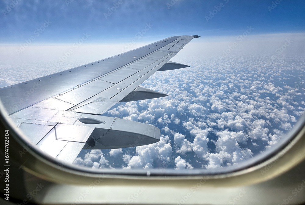 Obraz premium Beautiful cumulus clouds from the airplane window. Picturesque view from the airplane window at dawn.