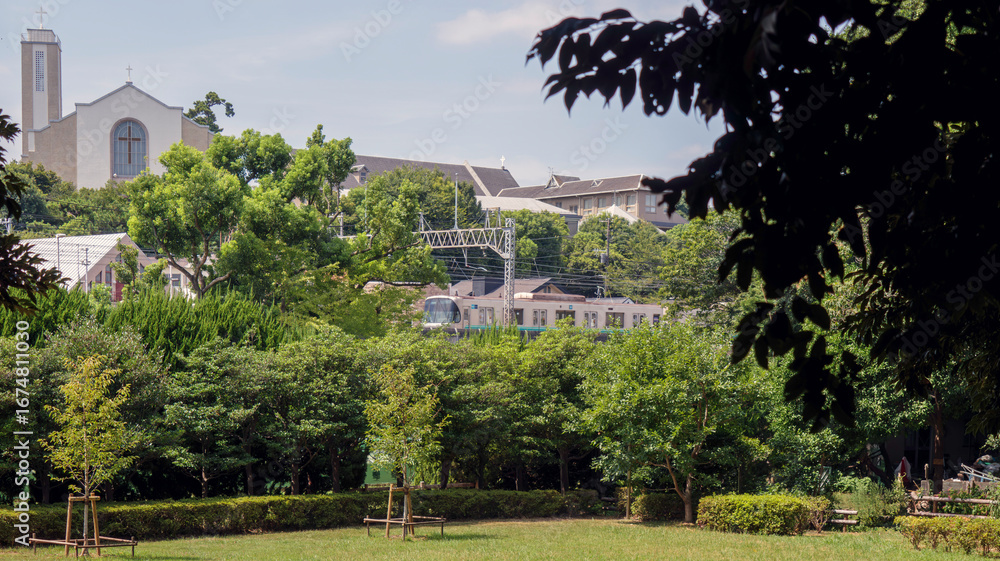 Naklejka premium 電車と教会が見える公園