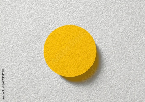 A bright yellow circle on a textured white surface