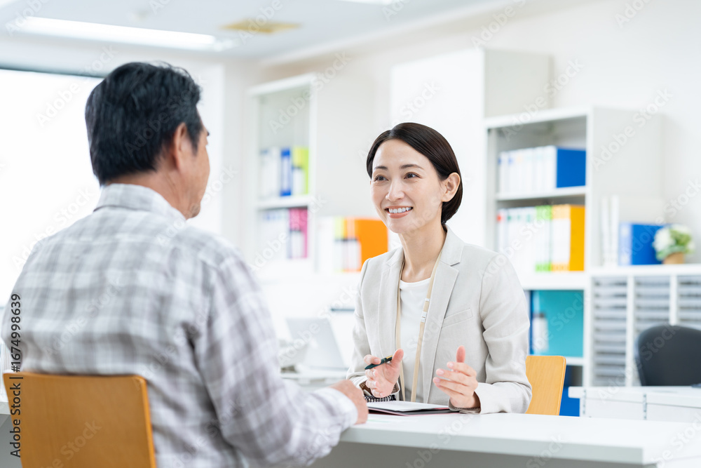 Fototapeta premium シニアの男性に営業するミドルのビジネスウーマン,ビジネス