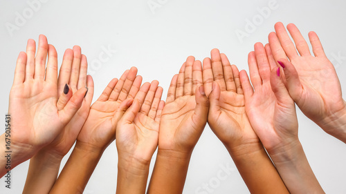 Diverse hands raised in unity showcasing different skin tones and gestures of inclusion