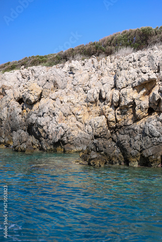 Rocky island in the sea on sunny day and blue sky. Blue water on Mediterranean sea