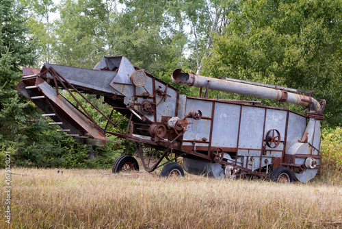 Fotografia Antique threshing machine abandoned in a field