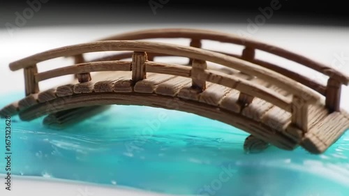 Wooden miniature bridge over teal water