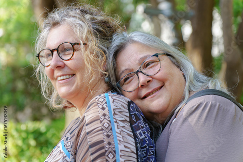 Happy mature lesbian couple enjoying a tender moment together in nature, celebrating their love and lgbtq pride