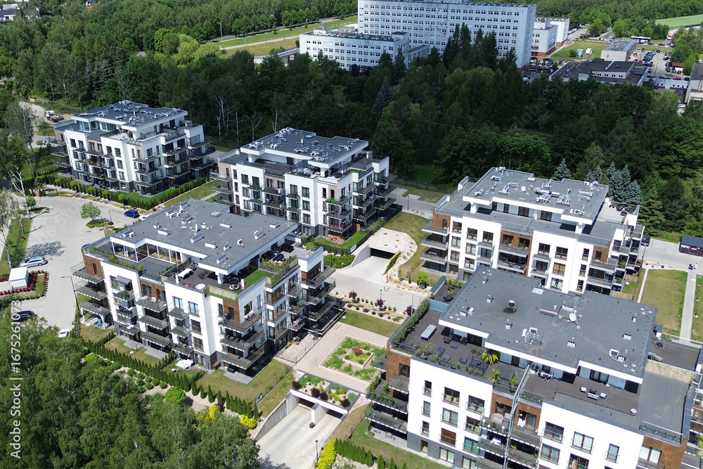 Fototapeta premium Aerial view modern low-rise apartment buildings surrounded by greenery