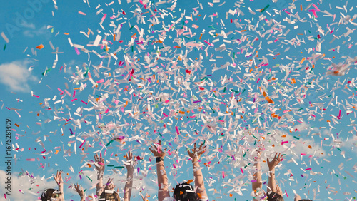 Canvastavla High school graduates celebrate by tossing colorful confetti into the sky agains