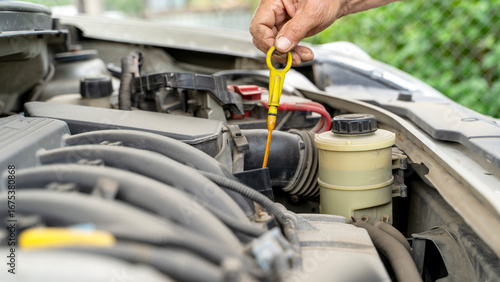 The driver checks the oil level in the car
