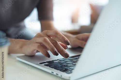 Photography Close up, woman hand typing, working on laptop computer on table at coffee shop