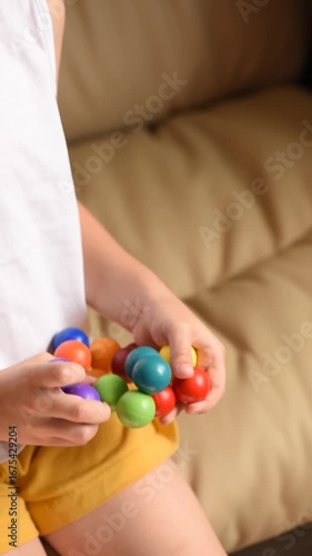 Closeup of children's hands with logic puzzle game with colorful balls