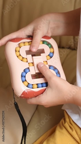 Closeup of children's hands with logic puzzle game with colorful balls