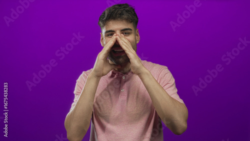 Bearded hispanic man cupping hands to mouth calls in a purple studio; urgent announcement communication energy.