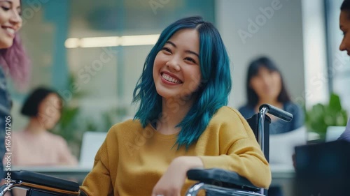 A woman in a wheelchair is smiling. She is wearing a yellow sweater. There are other people in the background