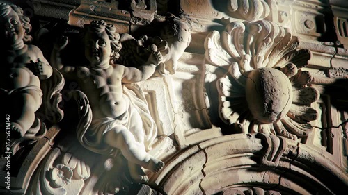 Stone cherubs and floral carving, architectural detail, ornate art.