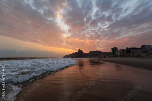 Bild auf Leinwand Wide horizontal shot of the vibrant sunset sky colors in Ipanema beach, in Rio de Janeiro, Brazil