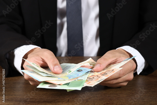 Wallpaper Mural Man with euro banknotes at wooden desk, closeup Torontodigital.ca
