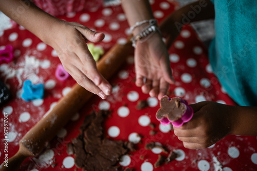 Children making cookies with chocolate dough and cookie cutters