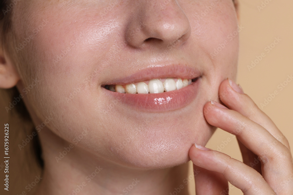 Obraz premium Smiling woman after dental aligners treatment on beige background, closeup