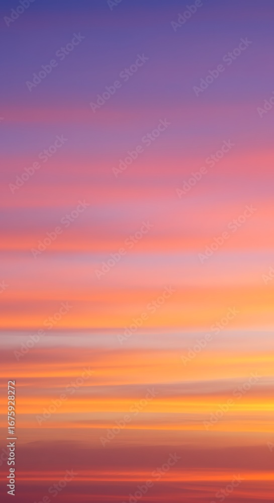 Obraz premium Vibrant sunset sky with horizontal bands of purple, pink, orange, and yellow hues creating a colorful gradient.