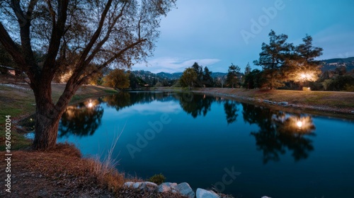Tranquil evening lake with reflections and trees at dusk.