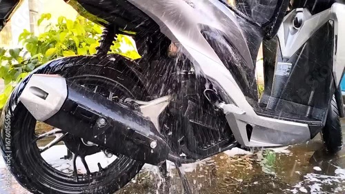 Spraying or washing a motorcycle with clean water in outdoor 