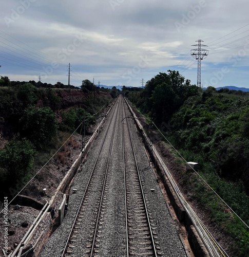Two pairs of parallel train tracks, photo taken on a bridge, the sky in the background of the tracks