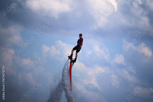 A man is riding a jet ski with a red tail