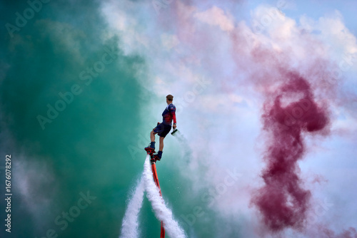 A man is riding a surfboard on top of a jet ski