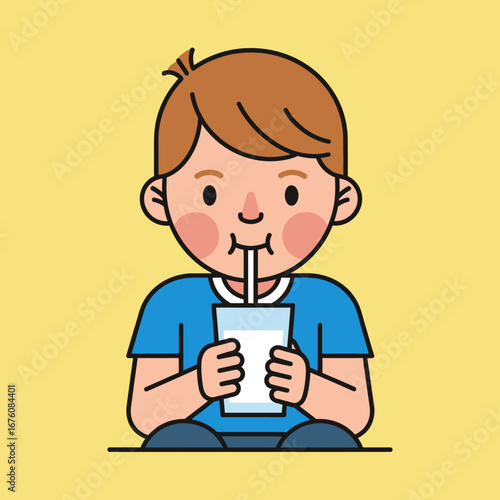 A young boy in a blue shirt is drinking milk from a glass with a straw.