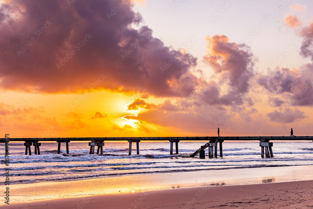 Fototapeta premium Butwani bridge and Malindi Pier area is a popular waterfront location known for stunning sunrises over the Indian Ocean. The pier is a concrete jetty that stretches about 400 meters into the ocean and