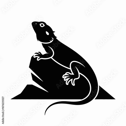 Silhouette of a bearded dragon perched on a rock