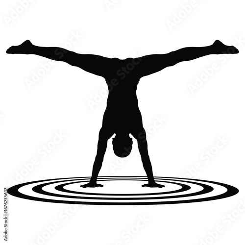 Athlete performing a handstand with legs spread wide in silhouette
