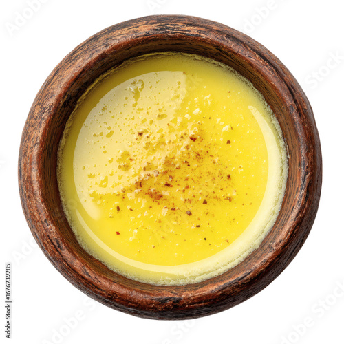 Top view of savory custard dessert garnished with spices in rustic brown wooden bowl isolated on white background
