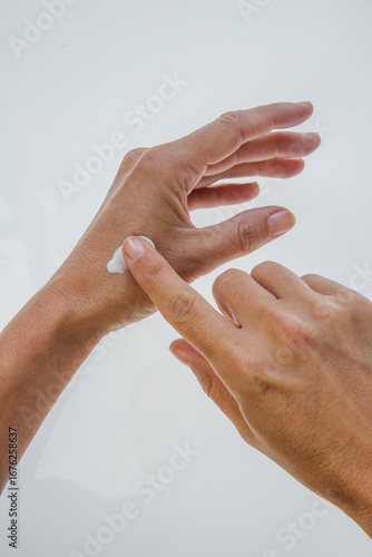 female hands applying cream on her hands