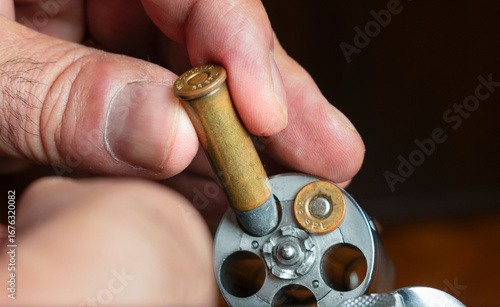 Focused older man preparing a revolver for action