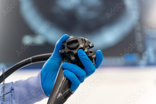 Hands with medical gloves holding Endoscopy equipment in front of monitor