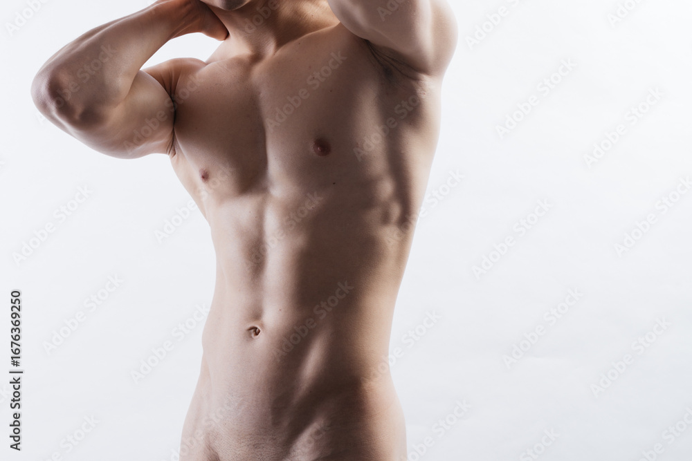 Fototapeta premium a dried male torso in close-up on a white isolated background. a male body after exhausting workouts and diets. clean skin and firm bodybuilder muscles