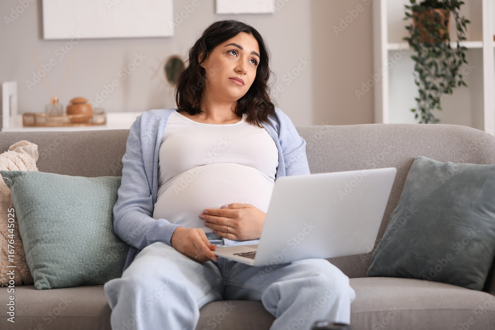 Tired young pregnant woman working with laptop at home Tired young pregnant woman working with laptop at home